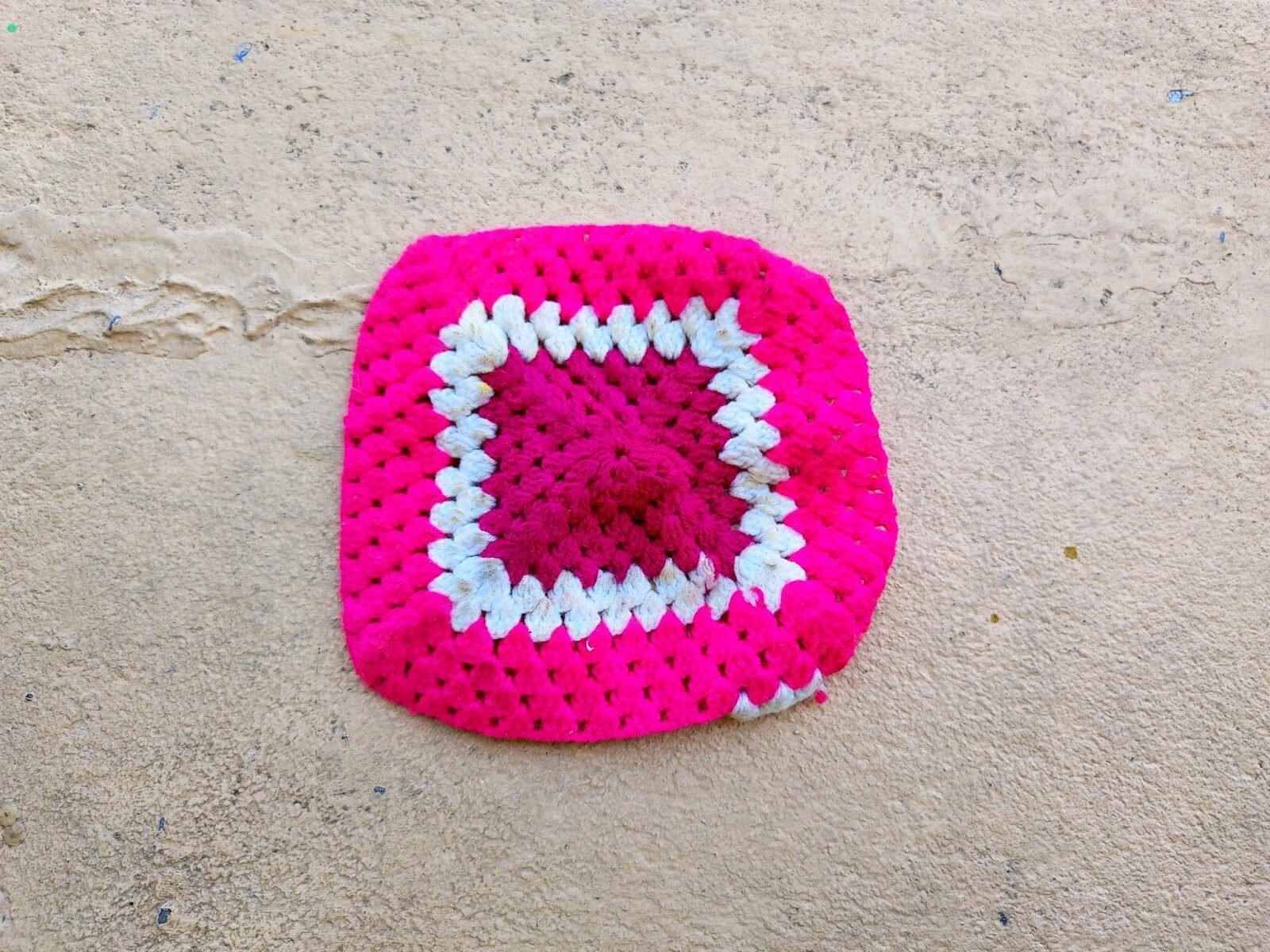 Handmade crochet granny square in pink, magenta and white yarn