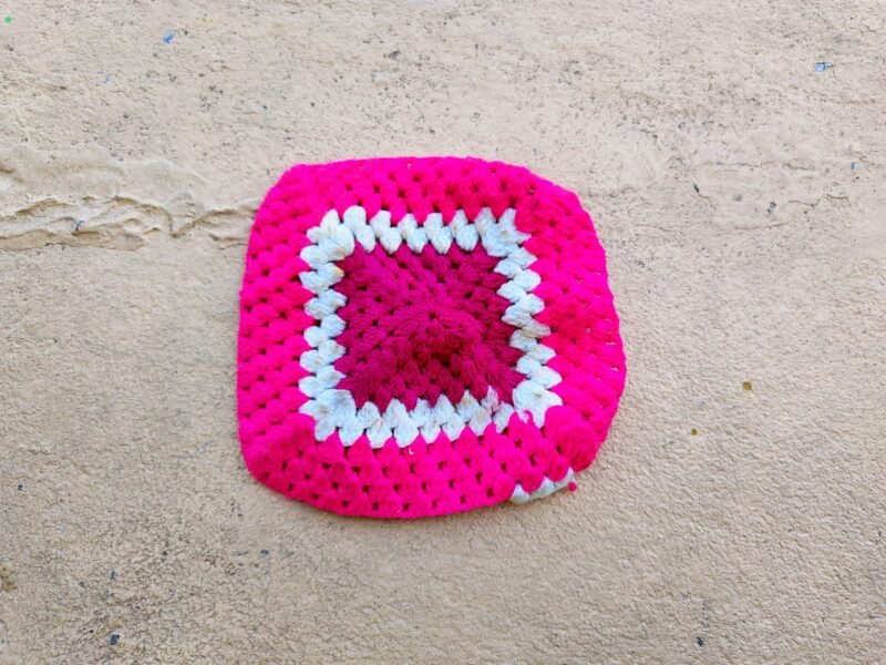 Handmade crochet granny square in pink, magenta and white yarn